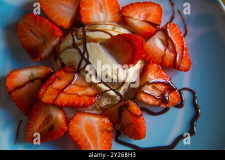 La crème glacée avec des fraises et du sirop de chocolat. Voir de très près. Banque D'Images