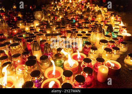 bougies brillantes dans des pots colorés lors de la veillée nocturne dans le cimetière Banque D'Images