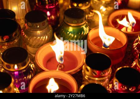 bougies brillantes dans des pots colorés lors de la veillée nocturne dans le cimetière Banque D'Images