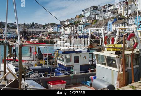 Bateaux de pêche amarrés DANS le port de Brixham avec le quai et les maisons en arrière-plan, Devon UK Banque D'Images