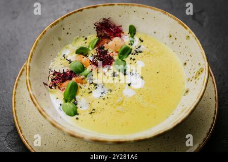 Soupe gastronomique crémeuse avec crevettes, microgreens et présentation artistique - plat gastronomique élégant Banque D'Images
