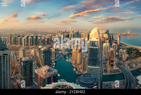 Vue sur les gratte-ciel de Dubaï au lever du soleil d'en haut. Nuages colorés et couleurs chaudes de terre ensoleillées en beau contraste avec le bleu et le sarcelle Banque D'Images