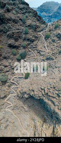 Vue aérienne du sentier à travers les montagnes jusqu'à la plage de Guigui, plage de sable noir immaculé, Gran Canaria. Espagne. Sentier pittoresque Banque D'Images