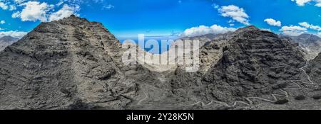 Vue aérienne du sentier à travers les montagnes jusqu'à la plage de Guigui, plage de sable noir immaculé, Gran Canaria. Espagne. Sentier pittoresque Banque D'Images