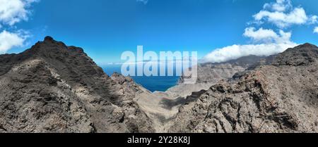 Vue aérienne du sentier à travers les montagnes jusqu'à la plage de Guigui, plage de sable noir immaculé, Gran Canaria. Espagne. Sentier pittoresque Banque D'Images