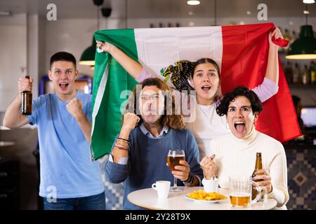 Joyeux fans de l'équipe mexicaine célébrant la victoire au bar de nuit Banque D'Images