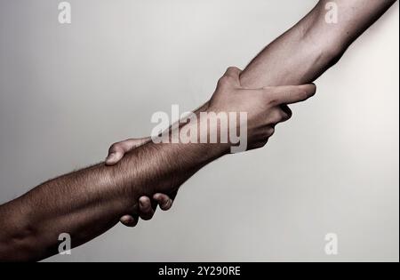 Sauvetage, geste d'aide ou mains. Maintien robuste. Deux mains, main d'aide d'un ami. Poignée de main, armes, amitié. Poignée de main amicale, salutation des amis Banque D'Images