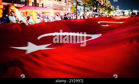 Izmir, Turquie. 09th Sep, 2024. L'anniversaire de la libération d'Izmir le 9 septembre, date importante de la guerre d'indépendance turque. Lors de l'événement où le 102e anniversaire de la libération d'Izmir de l'occupation ennemie a été célébré, un drapeau turc géant de 350 mètres a été porté par les personnes participant à la procession aux flambeaux. Crédit : İdil Toffolo/Alamy Live News Banque D'Images