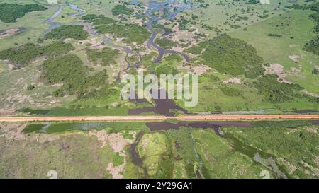 Vue aérienne de Transpantaneira route de terre traversant un lagon au-dessus d'un petit pont dans le paysage typique de North Pantanal Wetlands, Mato Grosso, Brazi Banque D'Images