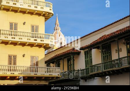 Vue sur les bâtiments historiques avec balcons, flèche de la cathédrale dans le dos contre le ciel bleu, Carthagène, Colombi Banque D'Images