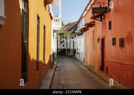 Rue étroite dans la vieille ville de Carthagène avec des maisons colorées d'un étage dans la lumière du soleil et l'ombre, Colombie, Amérique du Sud Banque D'Images