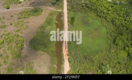 Vue aérienne rapprochée d'une partie du chemin de terre Transpantaneira avec forêt, prairies et lagunes, marais du Pantanal, Mato Grosso, Brésil, Amérique du Sud Banque D'Images