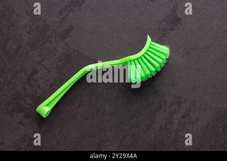 Brosse en plastique avec poils verts pour le nettoyage de la maison. Banque D'Images