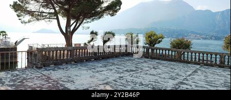 Panorama d'une place ouverte et balustrée dans la belle Bellagio sur les rives du lac de Côme, en Italie, arbres, montagnes et atmosphère alpine. Banque D'Images