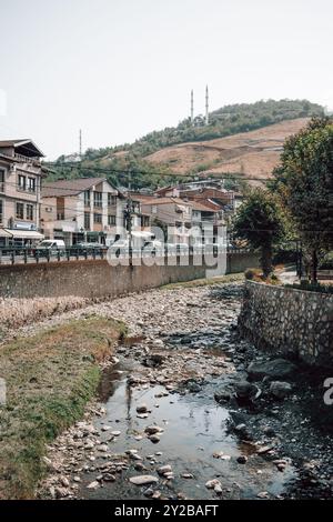 Le lit asséché de la rivière Bistrica dans le centre-ville de Prizren au Kosovo par une journée d'été ensoleillée, avec les minarets d'une mosquée en arrière-plan. Banque D'Images