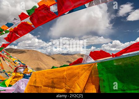 SHIGATSE, TIBET - 1er AOÛT 2022 : des drapeaux de prière tibétains colorés flottent au sommet du col de Kardung la en Inde, l'un des plus hauts cols de montagne motorisables Banque D'Images