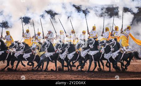 Au Maroc, Fantasia éblouit avec des couleurs vives et des affichages époustouflants. Chevaux majestueux et chevaliers courageux, drapés de robes vibrantes, charge en parfait Banque D'Images