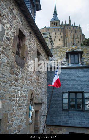 Bâtiments dans l'abbaye du Mont Saint Michel en Normandie, France avec drapeau national Banque D'Images