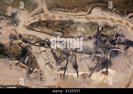 Vue aérienne d'une pelle chargeant de la pierre concassée dans un camion à benne basculante dans une carrière de pierre concassée Banque D'Images