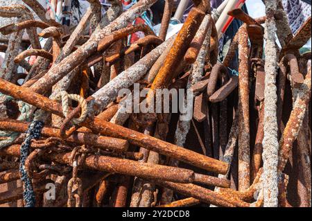 Une pile d'ancres en acier rouillé avec des cordes, des chaînes et des bernacles sur le rivage à Hastings, en Angleterre Banque D'Images