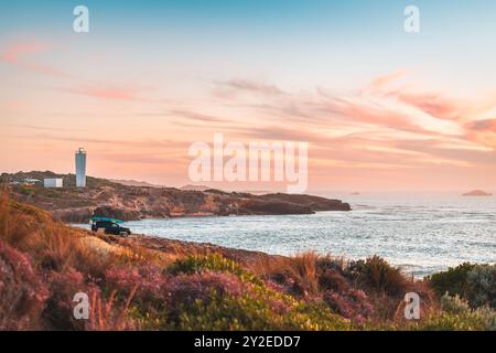 Voiture 4x4 garée sur la plage rocheuse en robe avec chauffeur profitant de la vue panoramique sur le coucher du soleil avec l'océan, Australie méridionale Banque D'Images