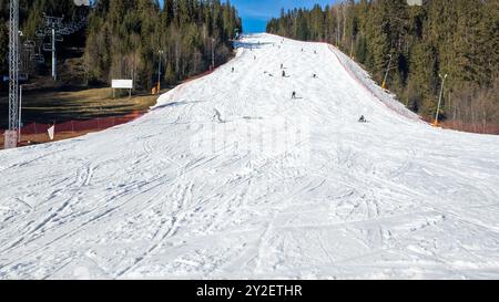 Pente de ski raide, télésiège, skieurs et snowboarders dans la station de ski de Bialka Tatrzanska en Pologne en hiver. Large espace de copie sur la neige ci-dessous Banque D'Images