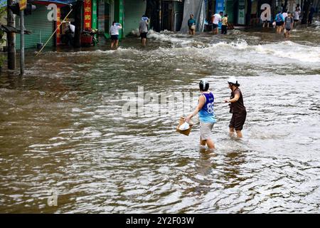 Hanoi, Vietnam. 10 septembre 2024. Les gens pataugeaient dans l'eau dans une rue à Hanoi, capitale du Vietnam, 10 septembre 2024. Le super typhon Yagi et ses inondations et glissements de terrain ultérieurs dans la région nord du Vietnam ont fait au moins 82 morts mardi en début d'après-midi tandis que 64 autres sont toujours portés disparus, a déclaré le ministère de l'Agriculture et du développement rural du pays. Crédit : VNA/Xinhua/Alamy Live News Banque D'Images