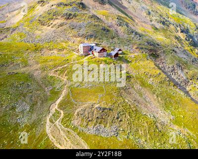 Le Breslauer Hut se trouve en bonne place dans les Alpes d'Otztal, entouré de prairies verdoyantes et de terrains rocheux, invitant les randonneurs à explorer le magnifique paysage alpin par une journée ensoleillée. Banque D'Images