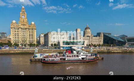 Embarcadère perceur de Liverpool avec le ferry Mersey The Royal Iris amarré avec les bâtiments des trois grâces. Banque D'Images