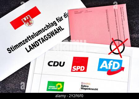 Bavière, Allemagne - 10 septembre 2024 : symbole de l'élection d'État dans le Brandebourg 2024, partis : AFD, BSW, Bündnis 90 die Grünen, CDU et SPD sur un bulletin de vote, à côté du drapeau d'une enveloppe de bulletin de vote postal. PHOTOMONTAGE *** Symbol zur Landtagswahl in Brandenburg 2024, Parteien : AFD, BSW, Bündnis 90 die Grünen, CDU und SPD auf einem Stimmzettel, neben Fahne eines Briefwahl-Umschlags. FOTOMONTAGE Banque D'Images