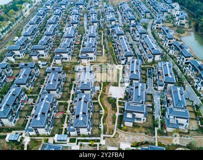 Vue aérienne d'une vaste communauté résidentielle avec des maisons modernes et des jardins paysagers dans une banlieue pendant la journée Banque D'Images