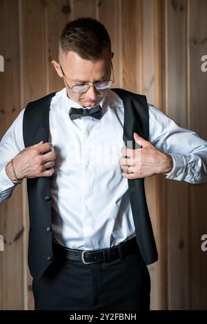 Marié élégant préparant pour le mariage dans la tenue classique noir et blanc. Banque D'Images