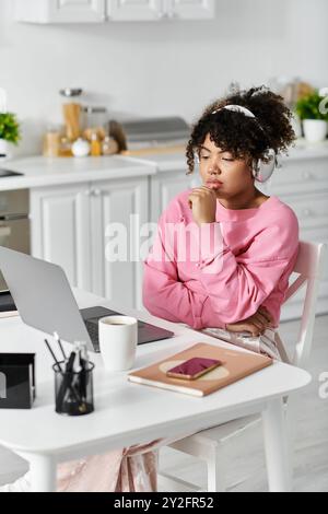 Une jeune femme profite de son temps à la maison, perdue dans la musique et la contemplation. Banque D'Images