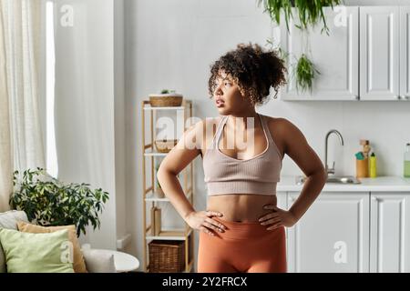 Une jeune femme profite de son temps à la maison tout en étant vêtue de vêtements de sport confortables. Banque D'Images