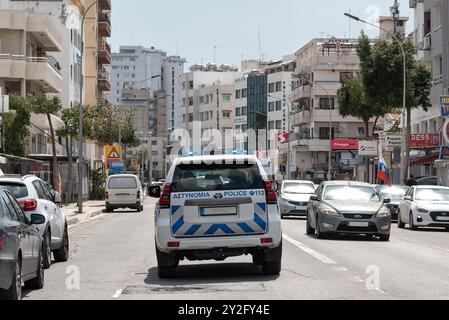 Larnaca, Chypre - 26 mars 2022 : une voiture de police patrouille dans une rue animée de Larnaca Banque D'Images