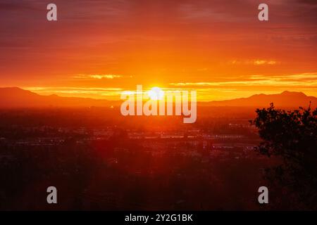 Soleil de l'aube de Los Angeles éclatant à travers des couches de brouillard au-dessus de la vallée de San Fernando. Banque D'Images