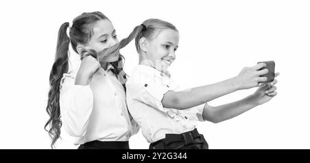 amis d'école bloguant et prenant selfie avec le téléphone dans la classe Banque D'Images