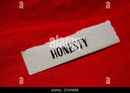 Message d'honnêteté écrit sur papier déchiré avec fond rouge. Symbole d'honnêteté conceptuel. Copier l'espace. Banque D'Images