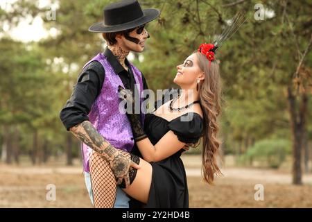 Jeune couple heureux habillé pour le jour des morts du Mexique (El Dia de Muertos) dansant dans le parc en plein air Banque D'Images