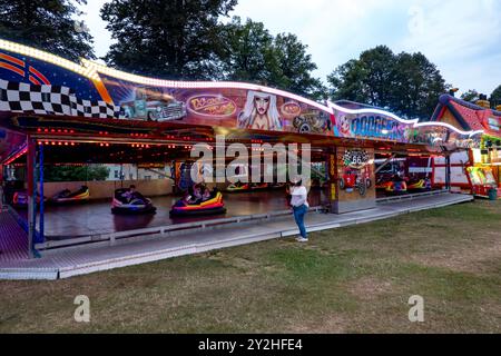 Les gens appréciant les voitures pare-chocs dodgems à un salon funfair itinérant à Saffron Walden, Essex, Royaume-Uni Banque D'Images