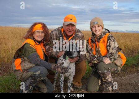 Owatonna (États-Unis d'Amérique). 14 octobre 2023. Le gouverneur du Minnesota Tim Walz, d-MN, au centre, pose avec un chien de chasse et un compagnon de chasse lors de l'ouverture de la saison de chasse des faisans, le 14 octobre 2023 à Owatonna, Minnesota. Crédit : MNGOV/Minnesota Governors Office/Alamy Live News Banque D'Images