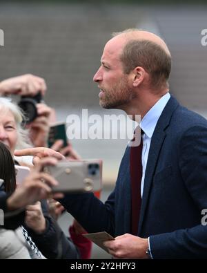 Llanelli, pays de Galles, Royaume-Uni 10 septembre 2024 SAR le Prince William, Prince de Galles salue ses sympathisants à l'extérieur de l'école primaire Swiss Valley, où il a rencontré des élèves qui ont participé à l'Urdd Eisteddfod 2024, un festival d'une semaine célébrant la langue et la culture galloises. Son voyage à Llanelli, dans le sud du pays de Galles, comprend également une visite à l'ambulance aérienne du pays de Galles dont il est le patron, et à Parc y Scarlets, le domicile de l'équipe de rugby à XV des Scarlets. Banque D'Images