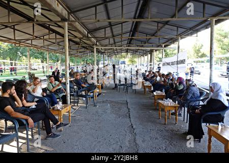 Des gens vus dans la tente de condoléances pour Narin Guran. Des organisations de femmes ont installé une tente de condoléances à Diyarbakir pour Narin Guran, une fillette de 8 ans dont le corps a été retrouvé 19 jours après sa disparition à Diyarbakir, en Turquie. La tente de condoléances dans le parc Kosuyolu a été organisée par le mouvement des femmes libres (TJA), l'Association des femmes Rosa, l'Association des droits de l'homme, l'Association des femmes pour la culture, les arts et la littérature (KASED), l'Association du Barreau de Diyarbak?R, la branche des femmes du Parti des régions démocratiques et les mères kurdes de la paix. Des centaines de personnes ont visité la tente et prié pour Narin Guran. (Photo de Mehmet Masum S Banque D'Images