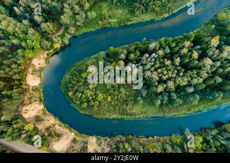 Vue aérienne de la rivière Sventoji serpentant à travers la forêt d'automne. Belle scène forestière aérienne près d'Anyksciai, Lituanie. Arbres verts et rivière sur f ensoleillé Banque D'Images