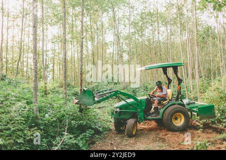 Un père et son fils travaillant sur un tracteur à la ferme. Banque D'Images