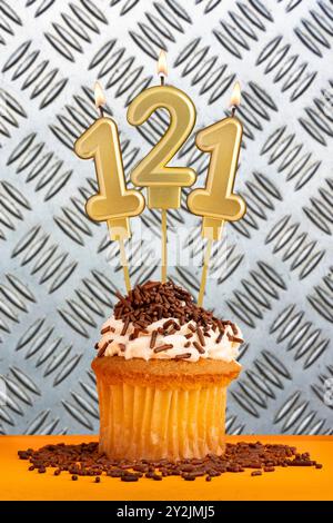 Cupcake au chocolat avec numéro de bougie 121 - anniversaire sur fond métallique industriel. Banque D'Images