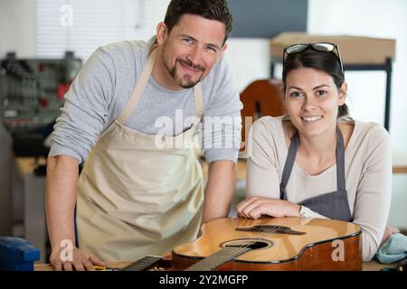 ouvriers hommes et femmes dans un atelier de guitare Banque D'Images