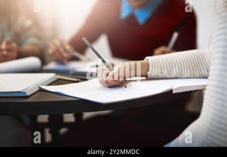 Main, étudiant et écriture de notes à l'université, apprentissage et dessin arbre de décision ou organigramme. Éducation, cahier et personne avec crayon pour Banque D'Images