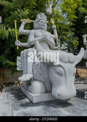 Statue de divinité à plusieurs bras assise sur un taureau au temple Ishiteji, Matsuyama, Japon, représentant la force et la puissance divine dans un cadre sacré Banque D'Images