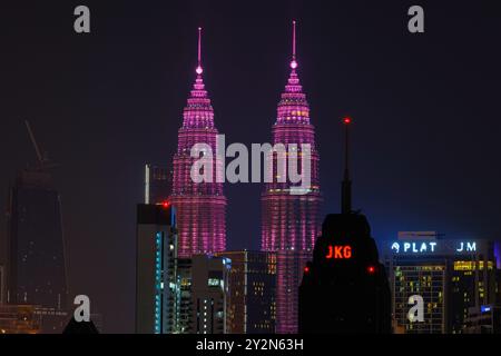 Tours jumelles Petronas (KLCC) avec les couleurs du drapeau rouge de la Malaisie, à Kuala Lumpur Malaisie la nuit, quelques heures avant le jour de l'indépendance 12h. Banque D'Images